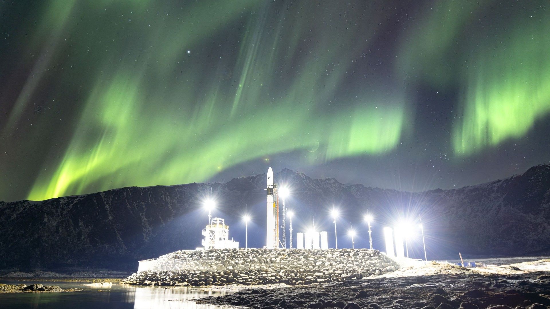 Foguete brilha sob a foto da aurora boreal do dia 25 de março de 2026